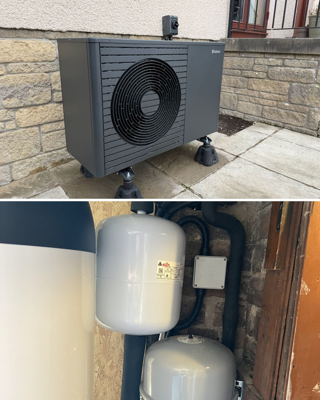 Heat pump installation in North Berwick: a black Vaillant aroTHERM heat pump on adjustable feet against a stone wall, and expansion vessels and pipework beside a hot water cylinder